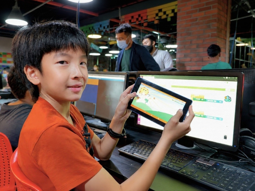 Ning Zhen Hao showing his mobile game on a tablet